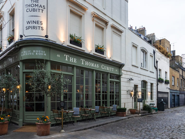 Green and white facade of Thomas Cubitt pub in London Belgravia.