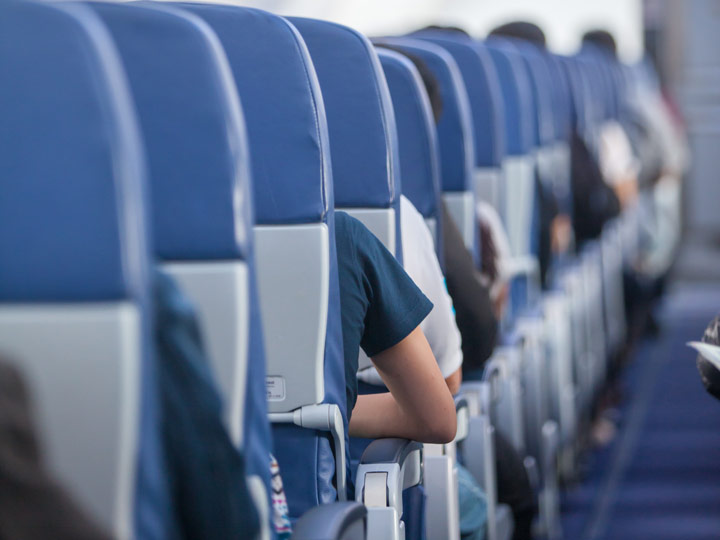 Airplane row of blue seats with armrests.