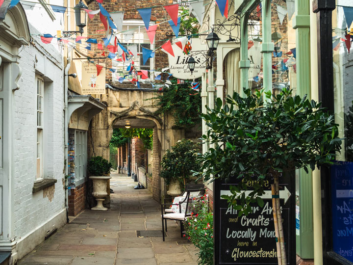 Charming alley of shops and bunting  with potted plants