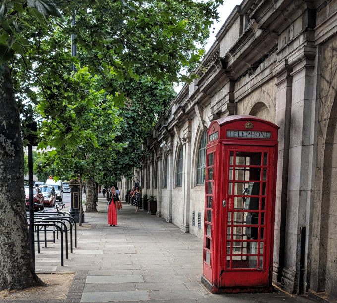7 Things Americans Should Know Before Moving to London from the US - Red phonebox on sidewalk near bridge.