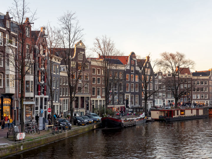 Sunset view of Amsterdam facades along canal.