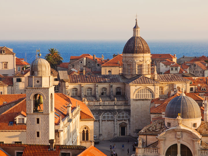 Sunset view of Dubrovnik city center with ocean in background.