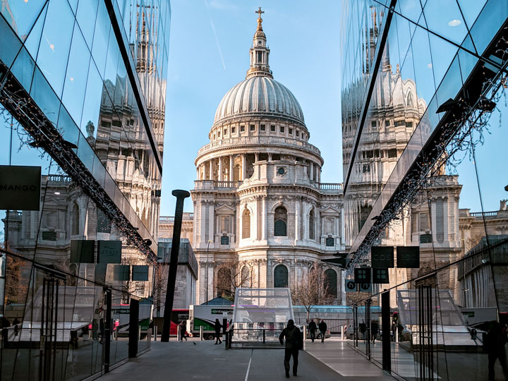 View of St. Pauls' Cathedral from alley with glass reflections.