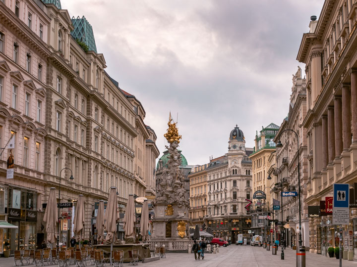 Vienna city center with tall buildings and gold statue in center.