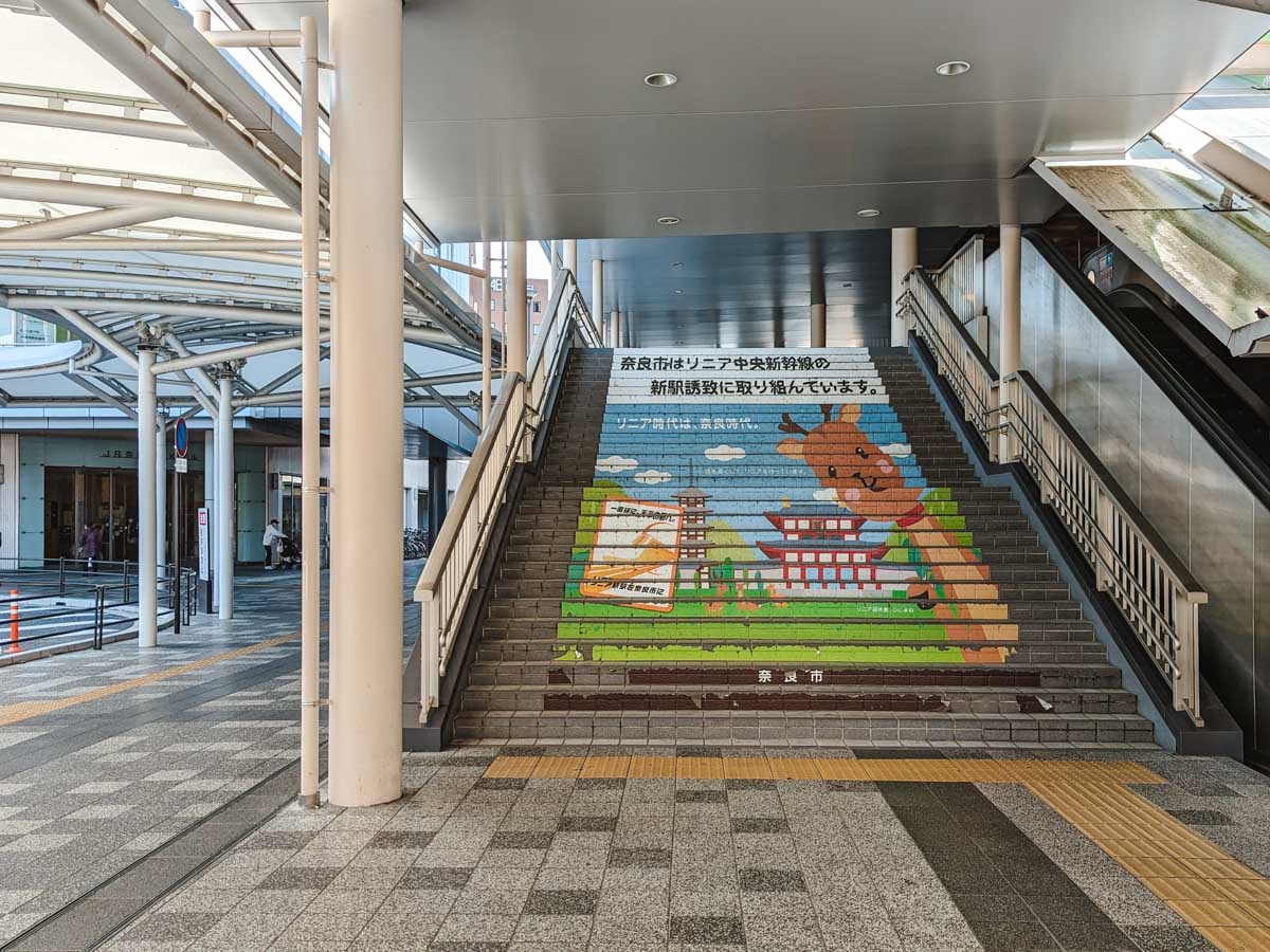 Stairs leading up to JR Nara Station with deer and temple mural.