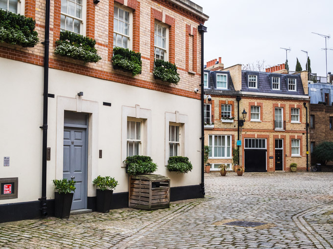 Row of mews houses and cobblestone street in Belgravia London.