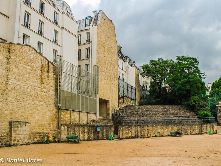 Paris Roman ampitheater ruins with apartments in background.