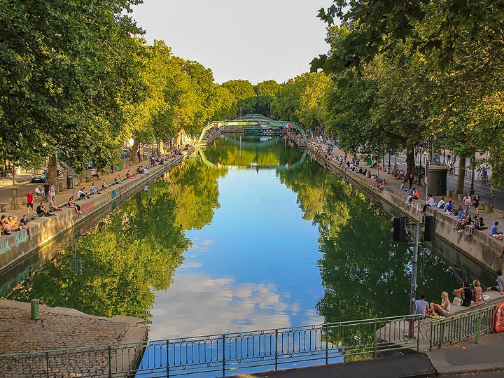 Paris Canal St. Martin on sunny day with sky reflection.