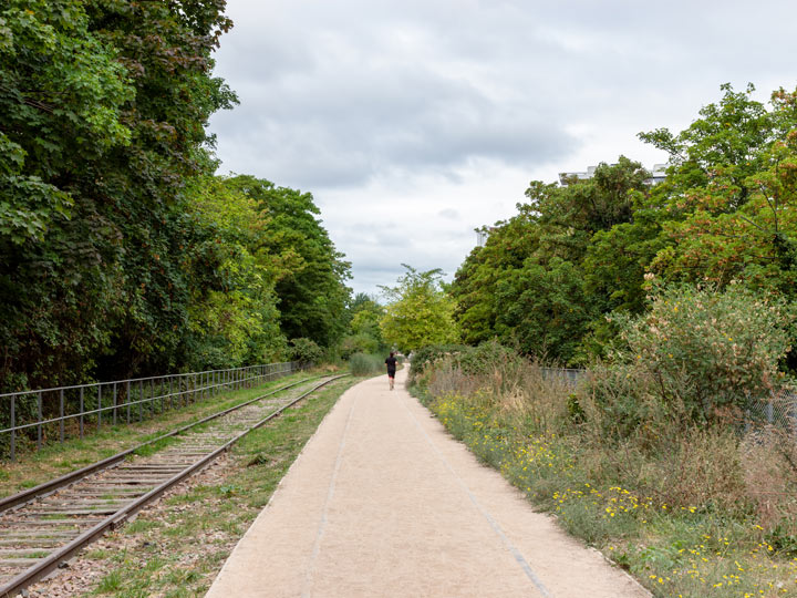 Paris Petite Ceinture walking path next to abandoned railroad tracks.