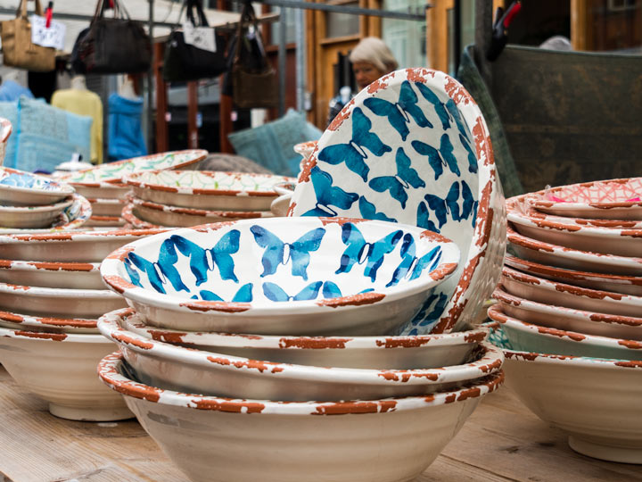 Blue butterfly print bowl on flea market table.