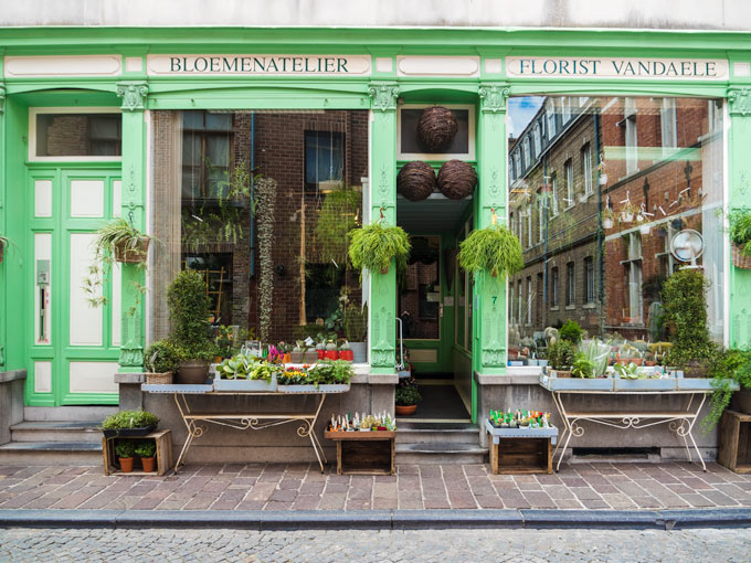 Green facade of florist in Bruges shopping area.