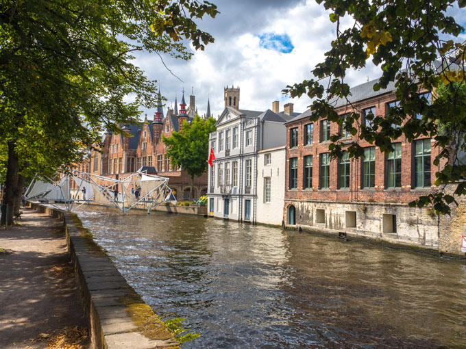 White bridge over Bruges canal, a popular sightseeing spot for a Bruges day trip.