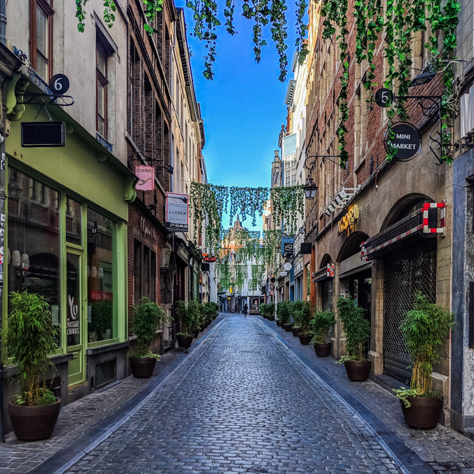 Tom smug med eføy og butikker sett på morgenen på en dag i Brussel