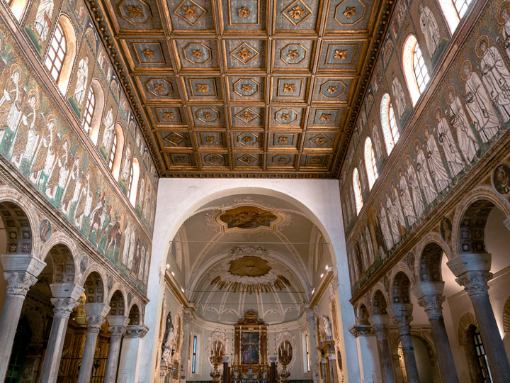 Ravenna Basilica di Sant'Apollinare Nuovo interior with blue and gold mosaics and ceiling.