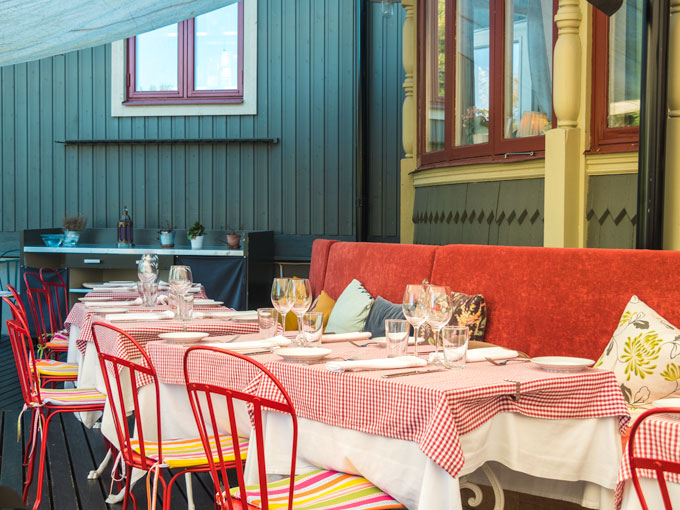 Stockholm Villa Godthem Restaurant with red checkered tablecloths and red seats.