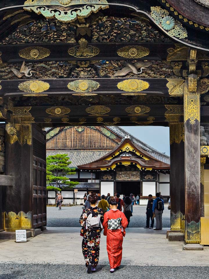 Two women in kimonos entering Nijo Castle wooden gate