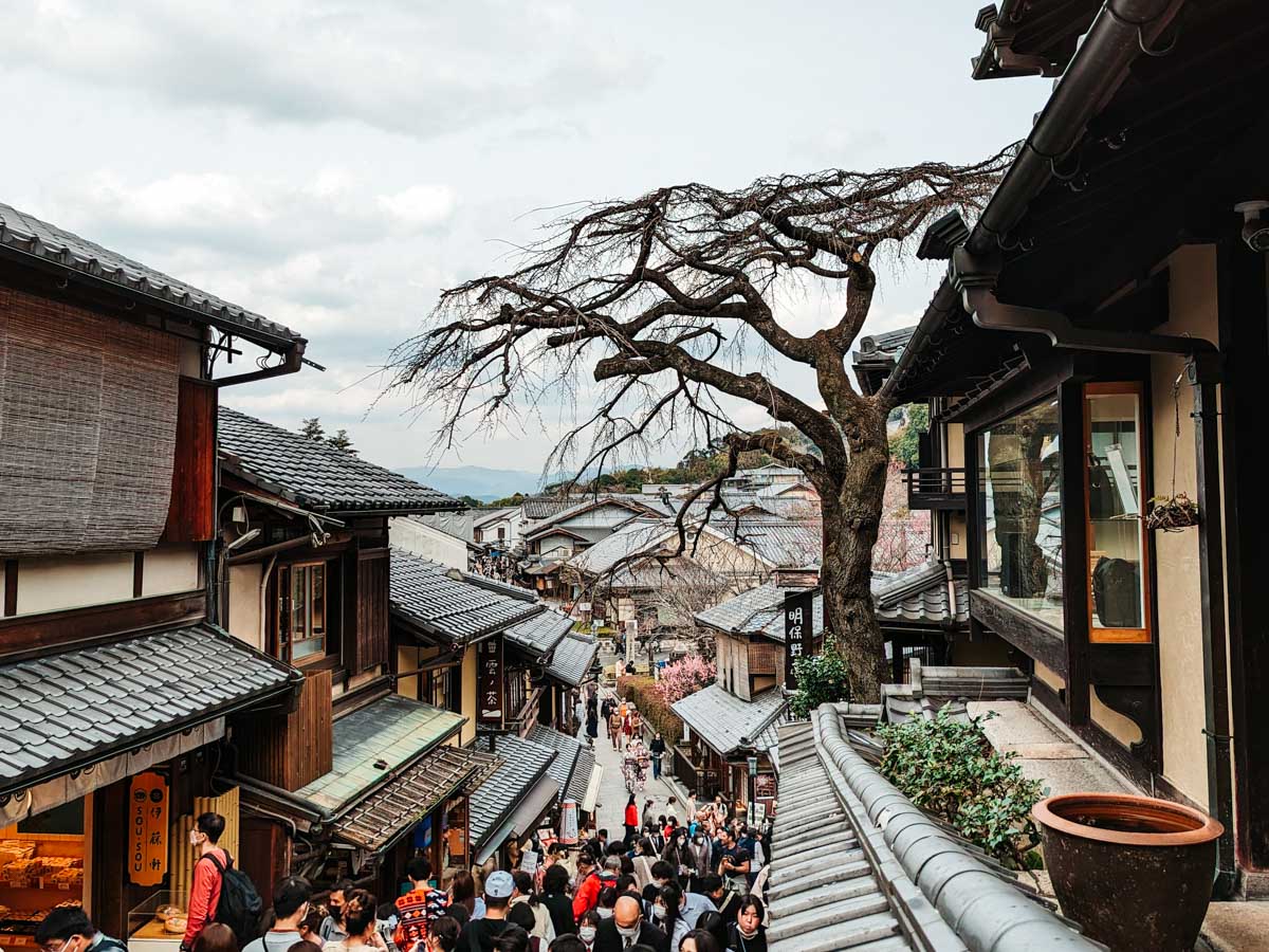 Overhead view of crowded Kyoto Sanenzaka alley lined with traditional Japanese buildings.