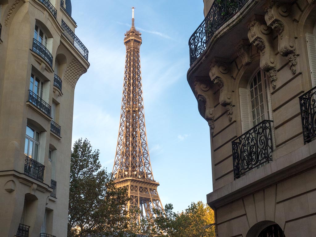 View of the Eiffel Tower between two buildings.