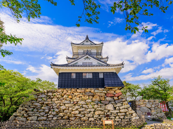 Hamamatsu castle view from below against partly cloudy sky.