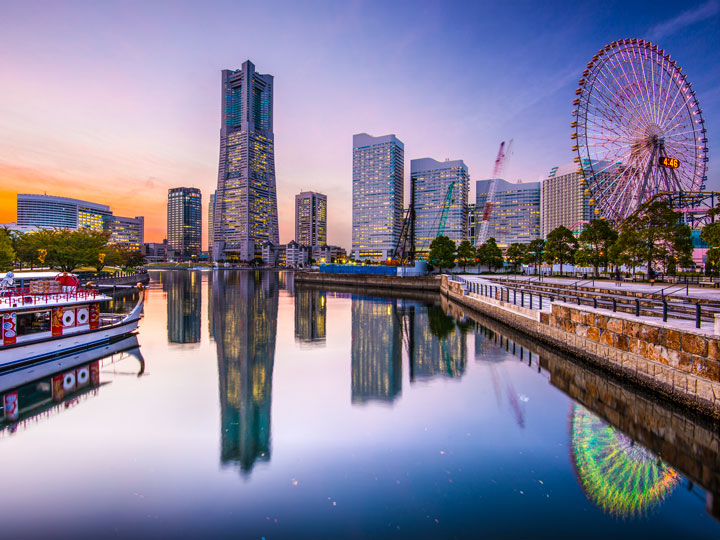 Yokohama Minato Mirai district with skyline and ferris wheel reflected in water.