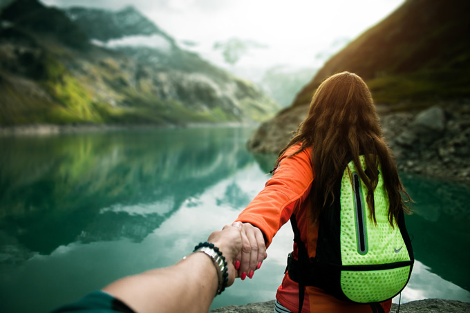 Couple hiking to mountain lake for romantic staycation.