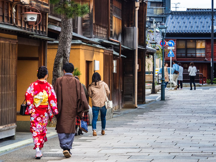 Japanese couple wearing yukatas walking down old street.