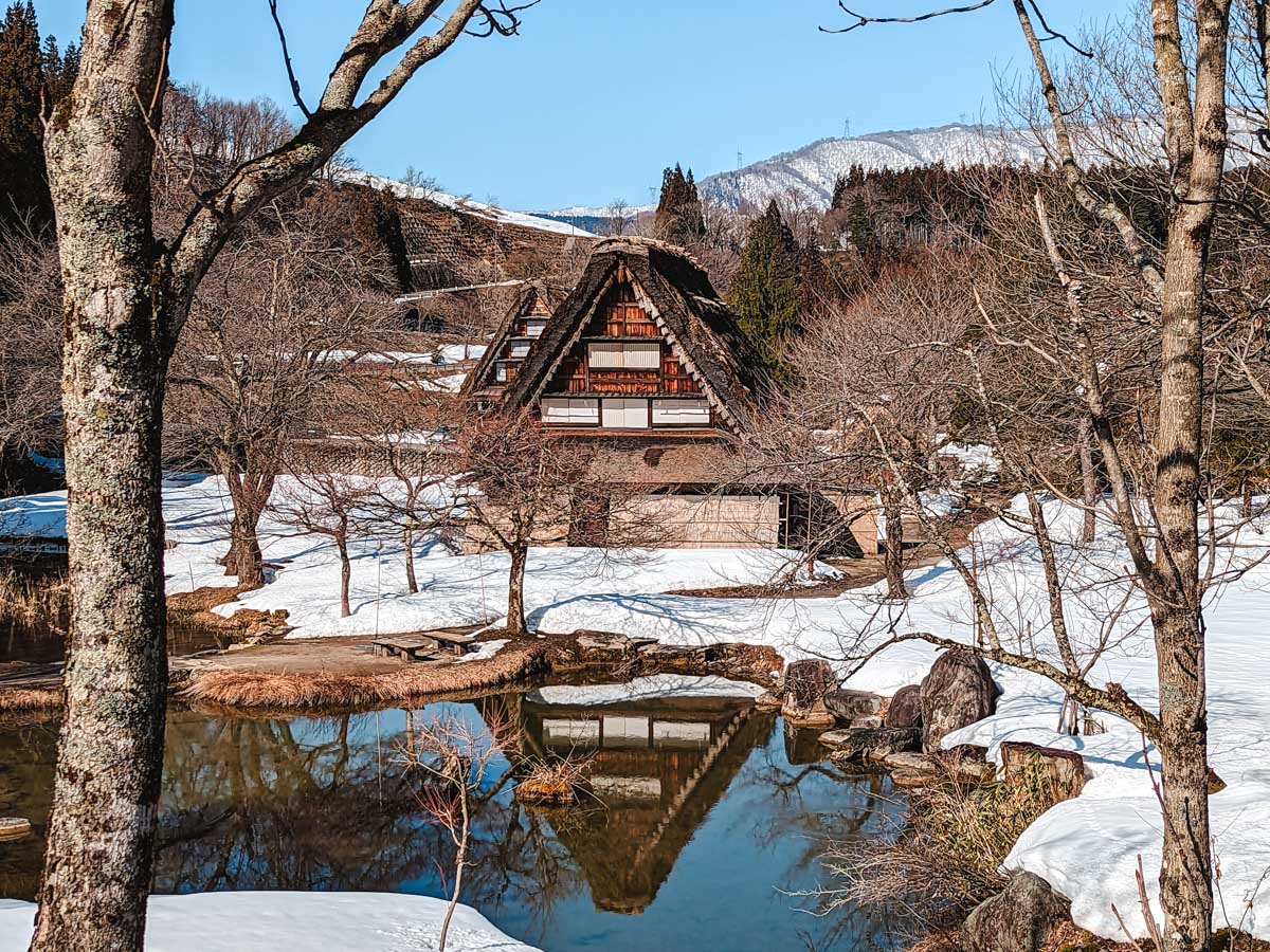 Old thatched roof house and reflecting pond in Shirakawago Gassho Zukuri museum.