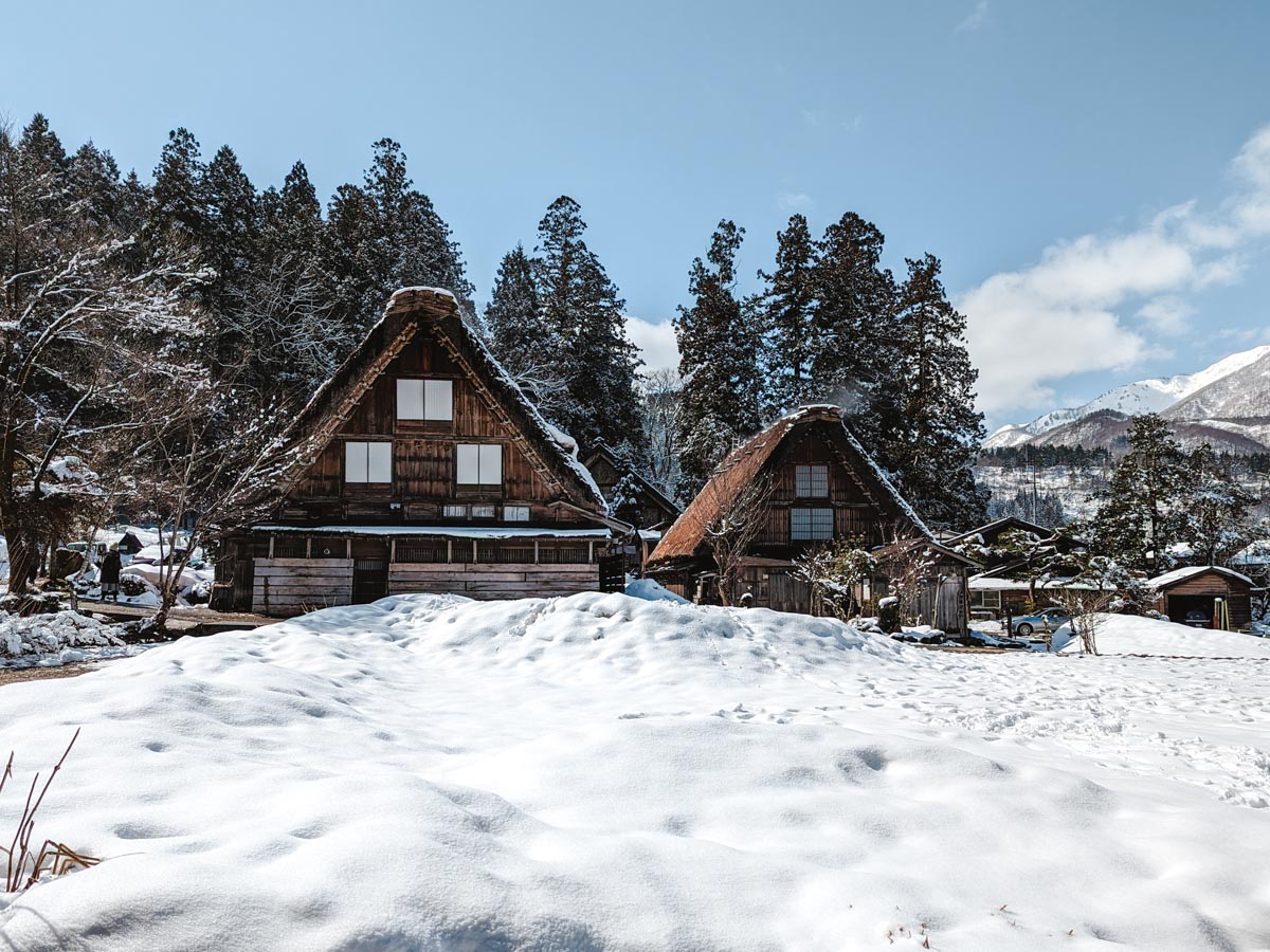 View of Shirakawago Nagase house with snowy field in forerground.