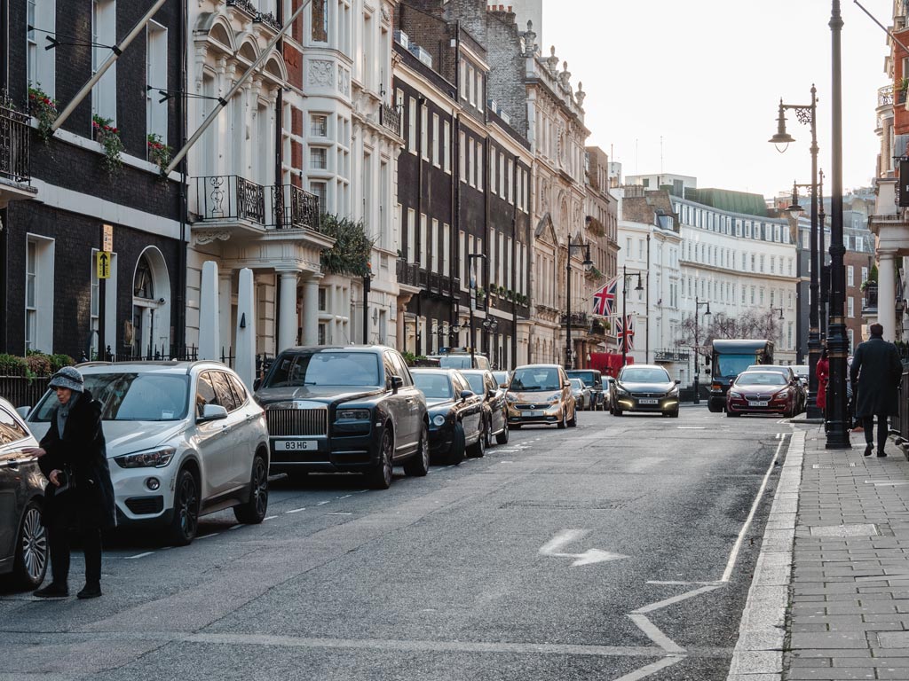 London street lined with cars and old homes.