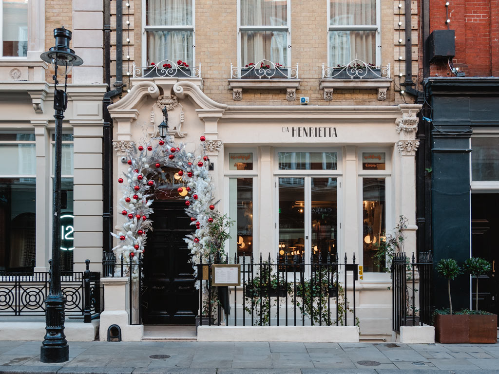 Facade of London cafe decorated with Christmas baubles.