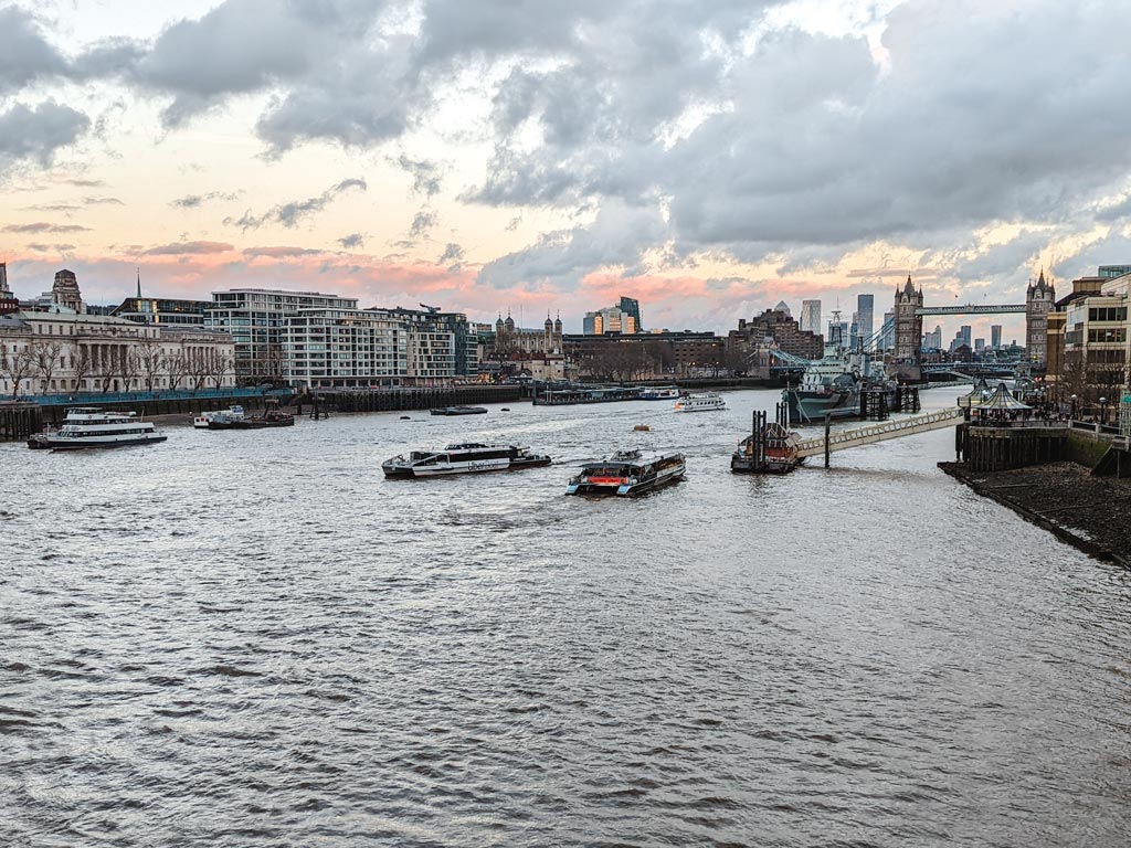 View of Thames River and London skyline at sunset.