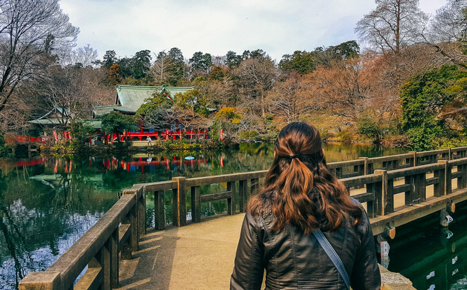 Woman looking at pond and bridge of Inokashira Park Kichijoji Tokyo.