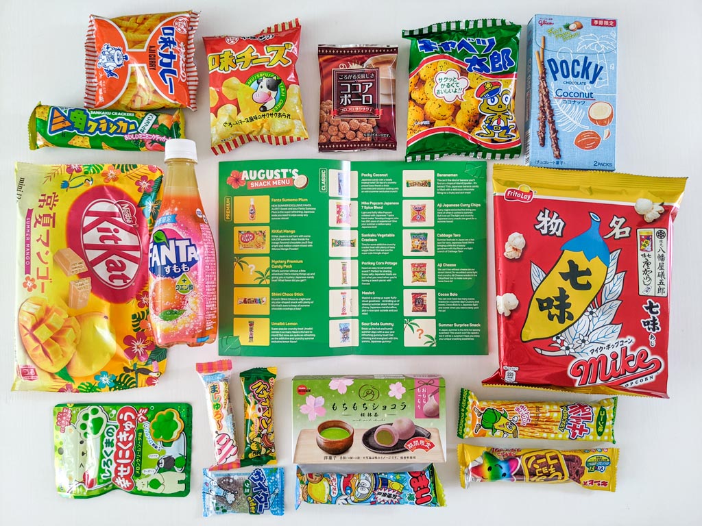 Arrangement of Japanese snacks from Tokyo Treat with guidebook at center.