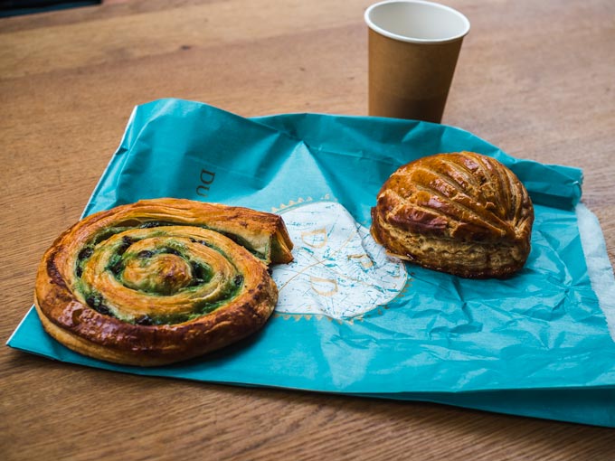 Two French pastries on blue paper bag.