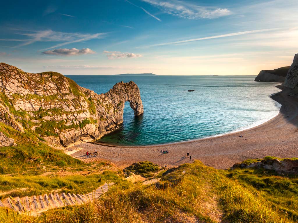 Sunset view of Dorset coast with Durdle Door rock formation.