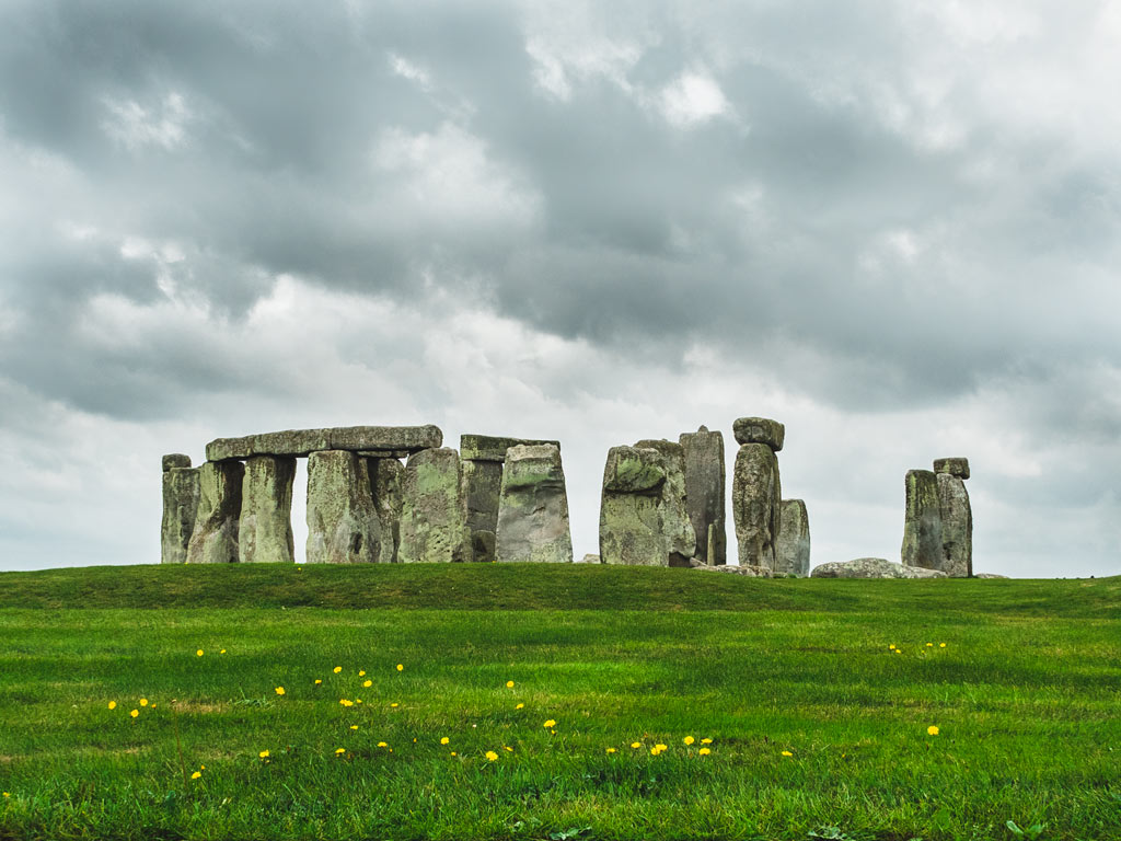 Stonehenge circle with grassy hill in foreground.