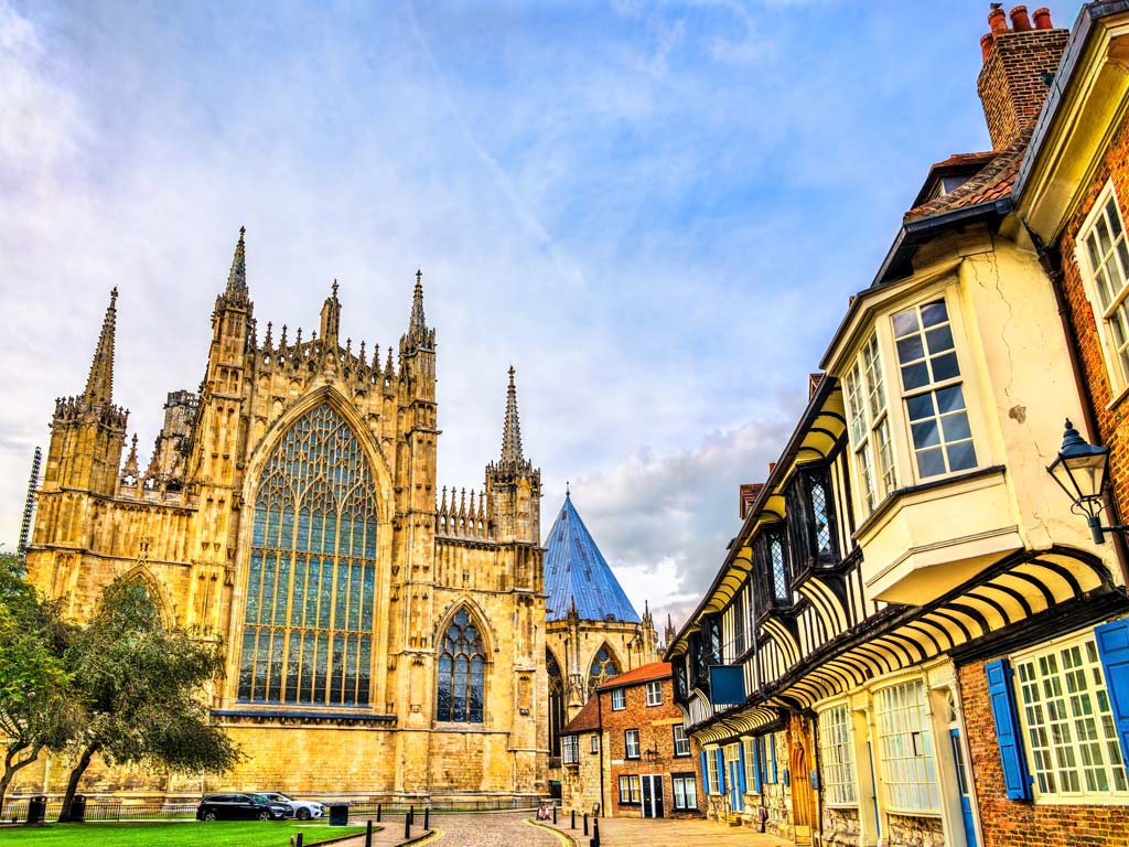 York Minster cathedral exterior with old half timbered houses on street.