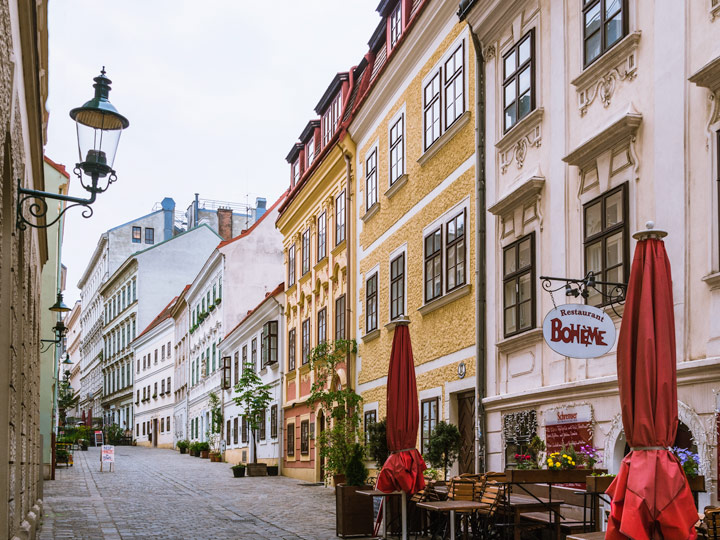 Vienna Spittelberggasse alley with colorful facades and outdoor cafe.