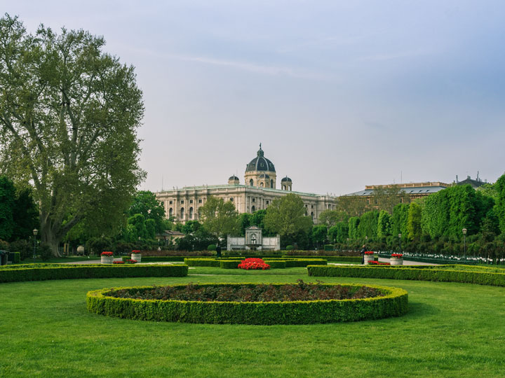 Green garden space and city view from Volksgarten, where to take a break during Vienna 2 day itinerary.