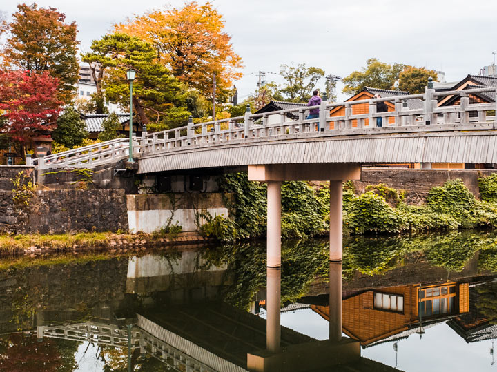 Kanazawa stone bridge over river viewed during autumn in Japan.