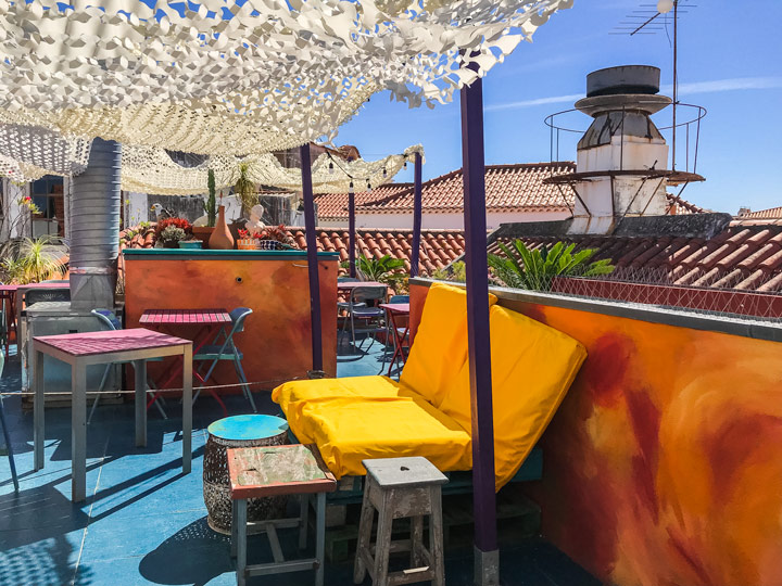 Rooftop patio at House of Wonders Cafe with yellow bench.