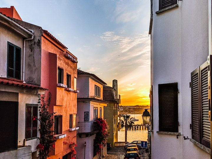 Sunrise view of Cascais from alley near ocean.